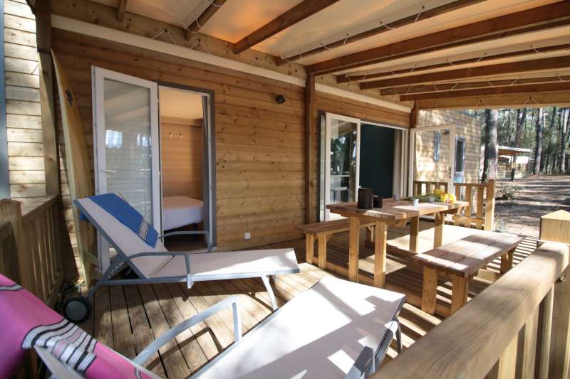 Terrasse en bois avec chaises longues dans la forêt